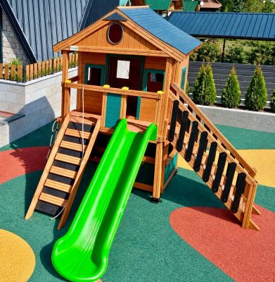 Maisonnette en bois avec toboggans verts — Elysee