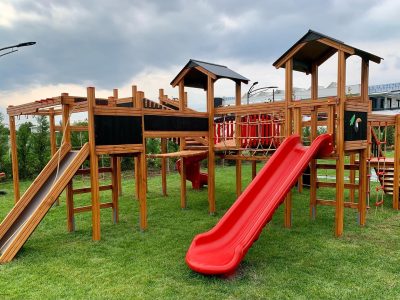 Aire de jeux en bois avec toboggans rouges — Elysee