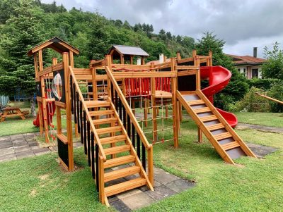 Aire de jeux en bois avec toboggans rouges — Elysee