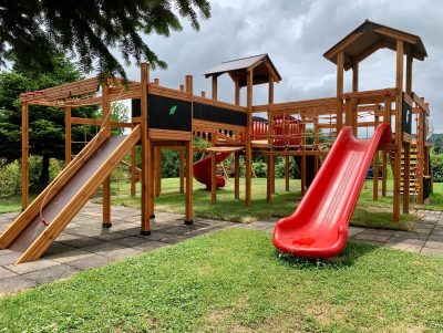 Aire de jeux en bois avec toboggans rouges — Elysee