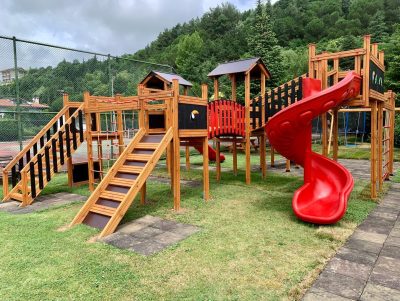 Aire de jeux en bois avec toboggans rouges — Elysee